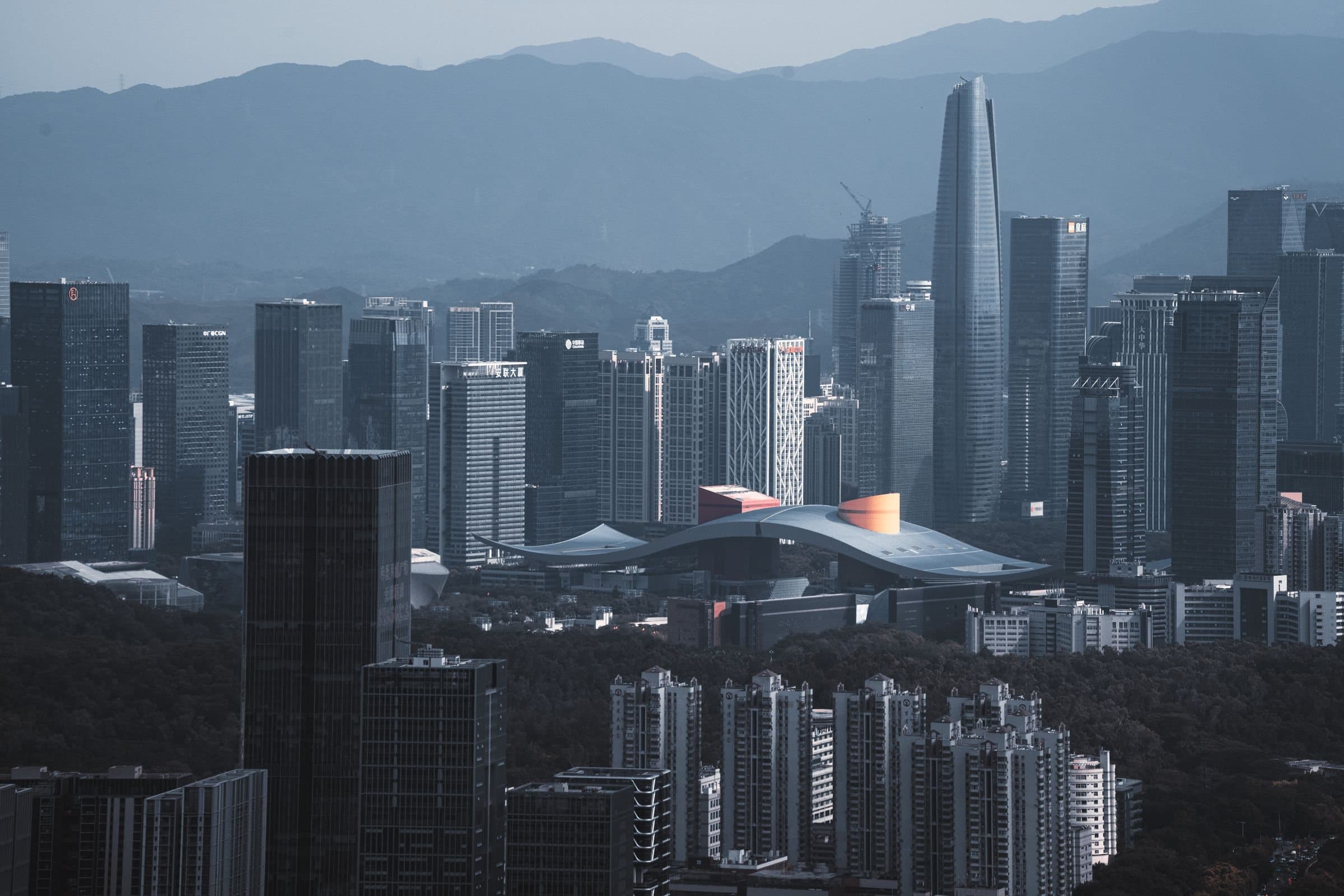 Futian's skyscrapers in Shenzhen, led by the Ping An Finance Centre, rising behind the wave-shaped roof of the Civic Center